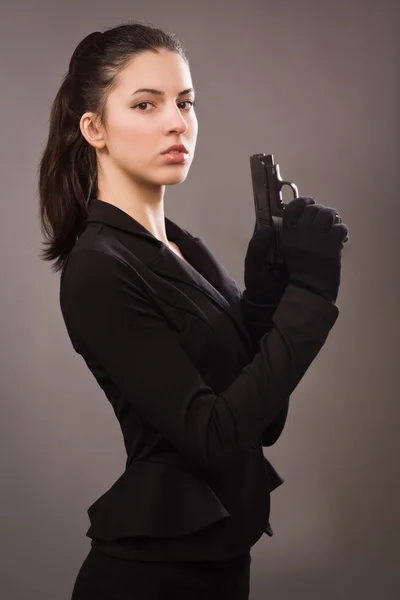 Espion fille dans un noir avec arme — Photo