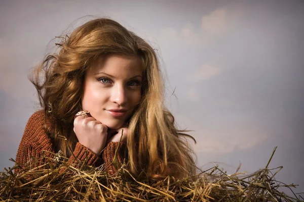 Pretty girl resting on straw bale — Stock Photo, Image