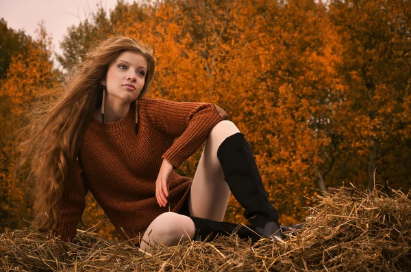 Красивая девушка отдыхает на соломенном тюке — стоковое фото