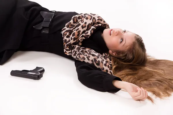 Menina espiã com arma deitada no chão — Fotografia de Stock