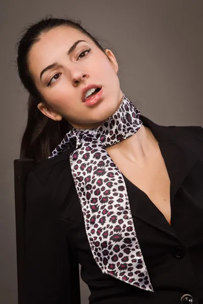 Vrouw in een zwart pak zittend op een tafel office — Stockfoto