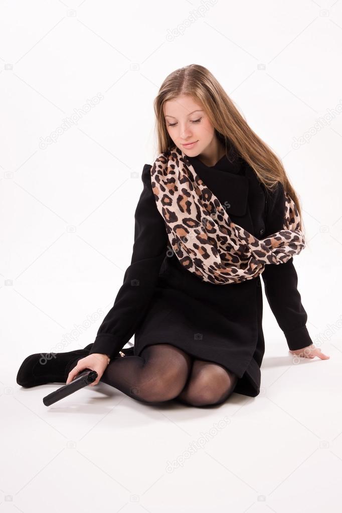 Spy girl in a black coat with gun