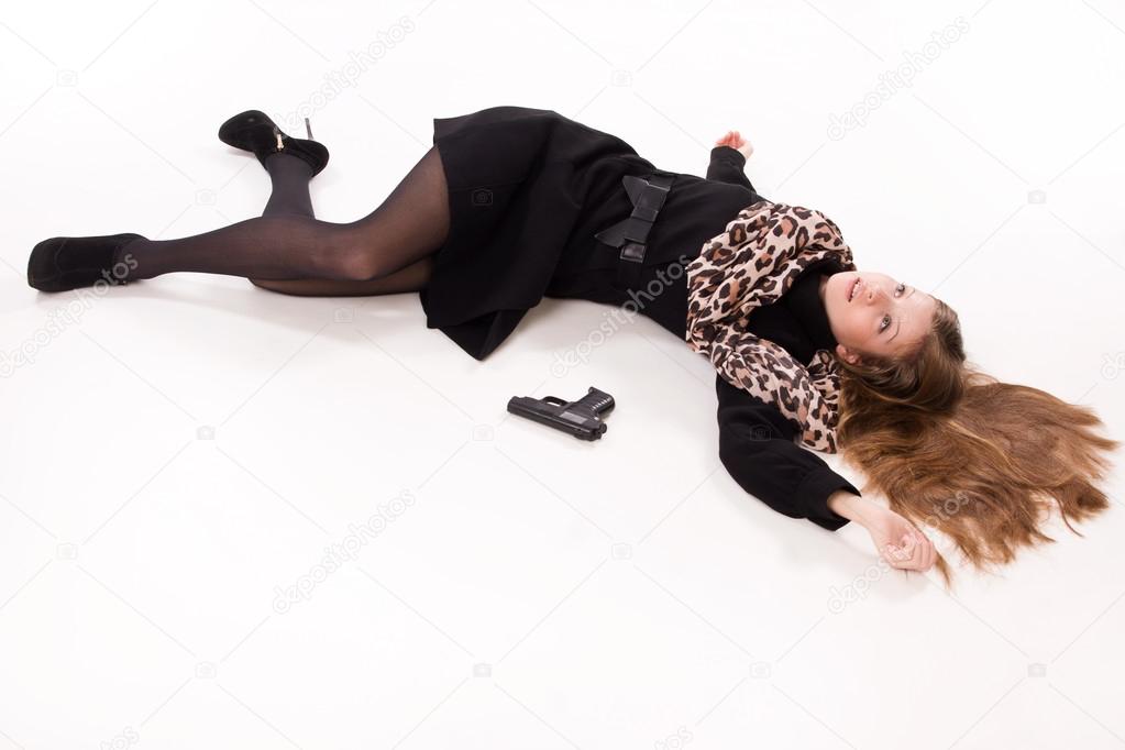 Spy girl with gun lying on the floor