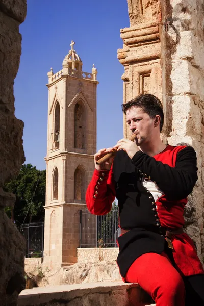 El hombre con traje medieval toca una flauta —  Fotos de Stock