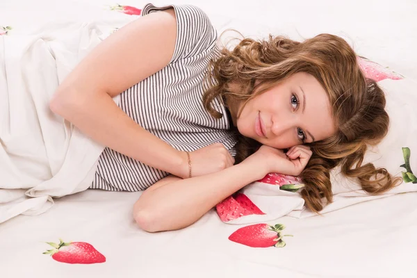 Красивая девушка лежит на кровати — стоковое фото