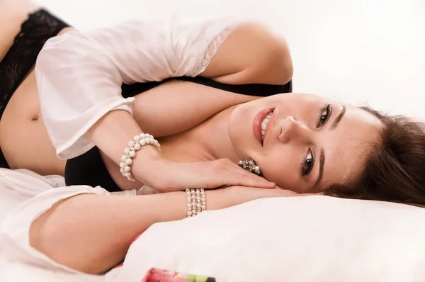 Seksuele brunette liggend op het bed — Stockfoto