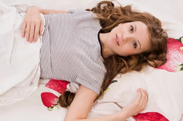 Docela blonďatá dívka leží na posteli — Stock fotografie