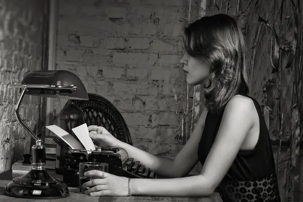 Mujer elegante en negro con la vieja máquina de escribir Fotos De Stock Sin Royalties Gratis