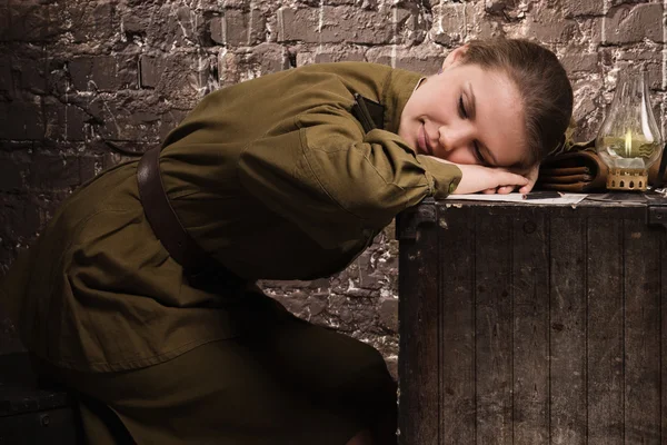 Sovjetiska kvinnlig soldat i uniform under andra världskriget som sover i en urholkad — Stockfoto