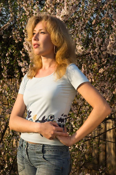 Beautyful blonde in een lentetuin — Stockfoto