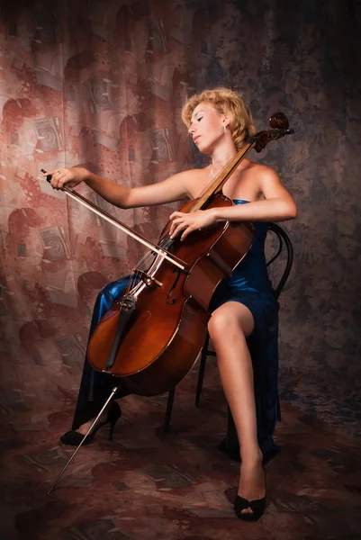 Mujer de belleza en vestido de noche tocando violonchelo — Foto de Stock