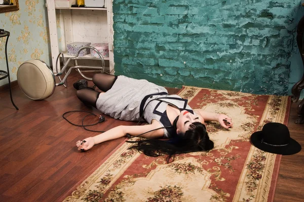 Crime scene simulation: strangled brunette on the floor — Stock Photo, Image