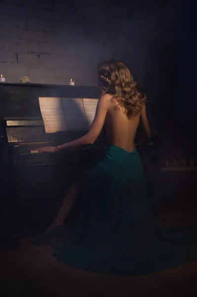 Mujer de belleza en vestido de noche tocando el piano — Foto de Stock