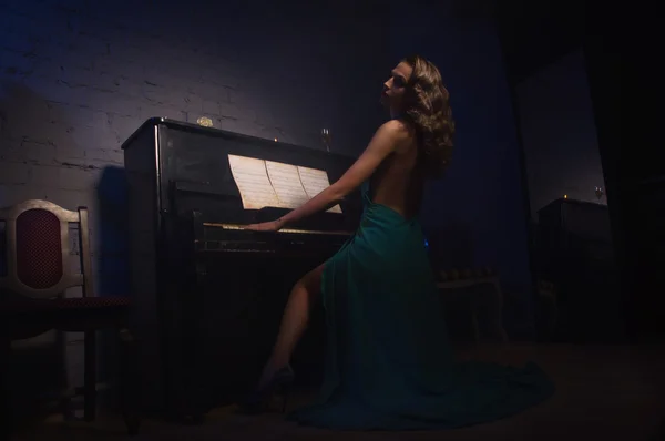 Mujer de belleza en vestido de noche tocando el piano —  Fotos de Stock