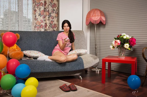 Attraktives Mädchen sitzt auf einem Sofa — Stockfoto