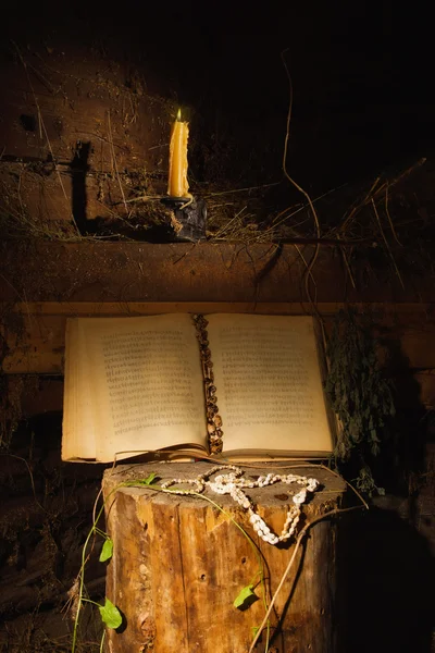 Vecchio libro e candela in un interno scuro — Foto Stock