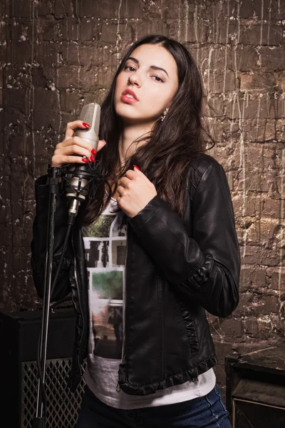 Rock babe singing into a microphone — Stock Photo, Image