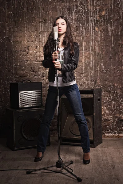 Rock babe singing into a microphone — Stock Photo, Image