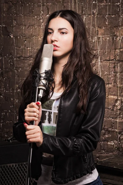 Rock babe singing into a microphone — Stock Photo, Image