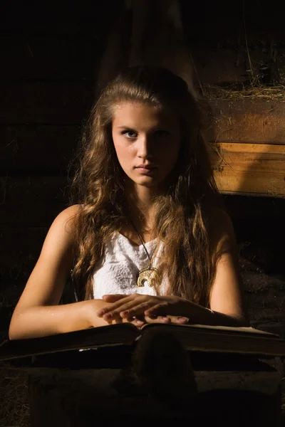 Eski bir karanlık iç kitabında ile oturan genç kız — Stok fotoğraf