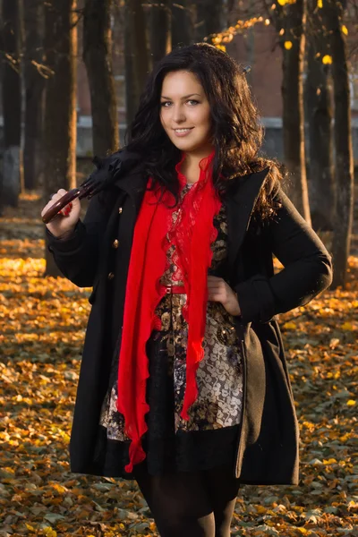 Pretty brunette in autumn park — Stock Photo, Image