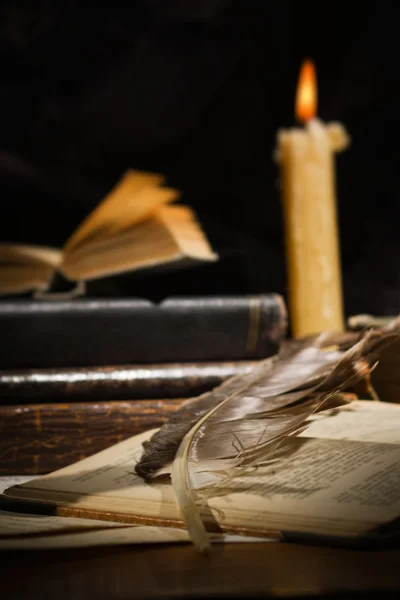 Old books and candles on wooden table — Stock Photo, Image