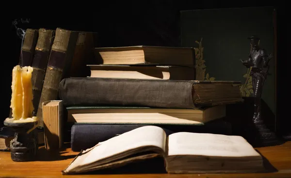 Libros antiguos y velas sobre mesa de madera —  Fotos de Stock