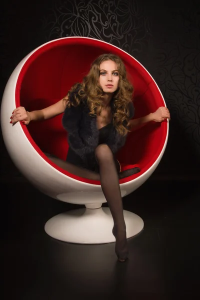 Sexuelle Frau sitzt im roten Ballstuhl — Stockfoto