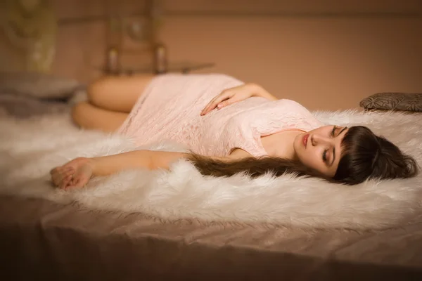 Young girl lying on the bed in an elegant bedroom — Stock Photo, Image