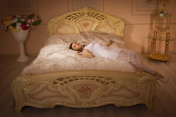 Elegant girl in evening dress in an elegant bedroom — Stock Photo, Image