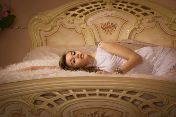 Elegant girl in evening dress in an elegant bedroom — Stock Photo, Image