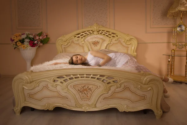 Menina em cima da cama em um quarto elegante — Fotografia de Stock