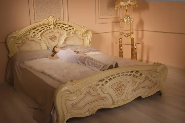 Jovem menina elegante deitado na cama — Fotografia de Stock