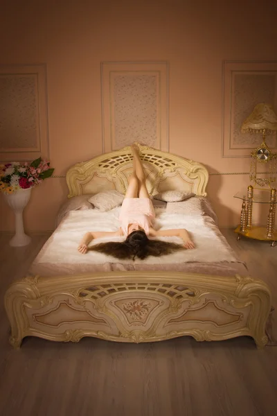 Young elegant girl lying on the bed — Stock Photo, Image