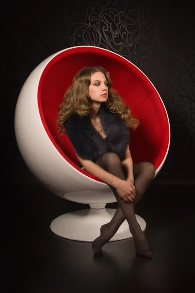 Sexual woman sitting in a red ball-chair — Stock Photo, Image