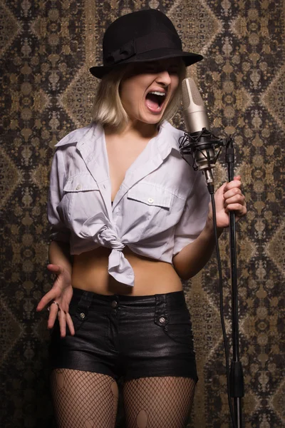 Rock babe singing into a microphone — Stock Photo, Image