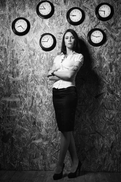 Office girl on a background of a wall clock — Stock Photo, Image