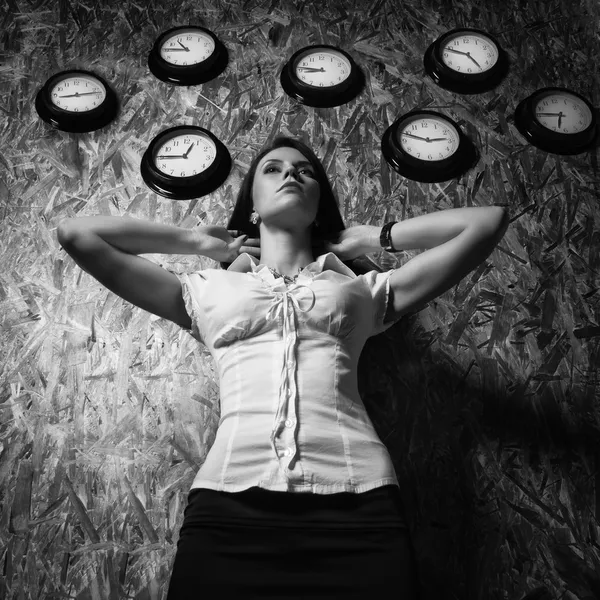 Office girl on a background of a wall clock — Stock Photo, Image