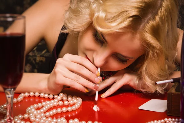 Sensual blonde lady in black sniffing cocaine (Imitation) — Stock Photo, Image