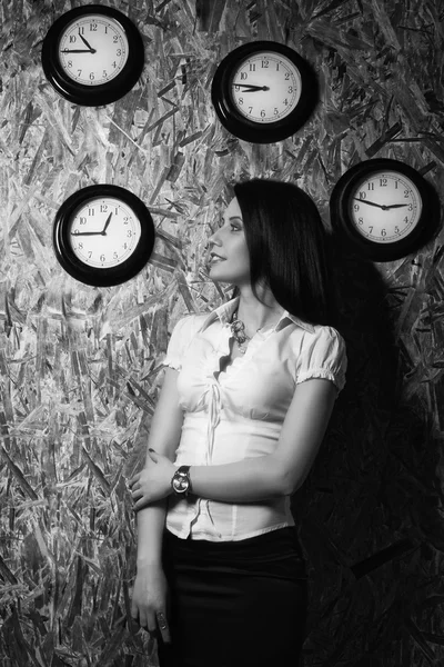 Κορίτσι γραφείου σε φόντο ένα ρολόι τοίχου — Φωτογραφία Αρχείου