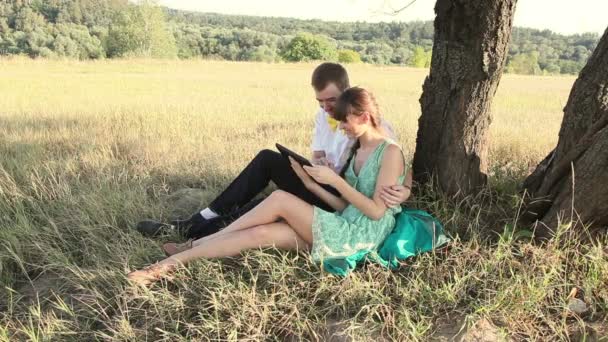 Νεαρό ζευγάρι στο Διαδίκτυο που κοιτάζει βιαστικά με δισκίο και συνομιλία. — Αρχείο Βίντεο