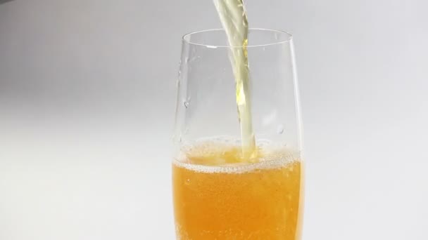 Cider flowing into the glass with bubbles isolated on white — Stock Video