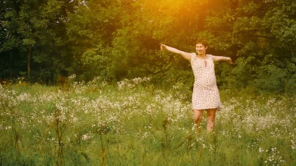 Mulher grávida dançando no campo ao pôr do sol — Vídeo de Stock