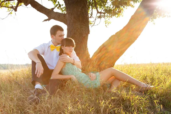Young couple lying under the tree — Stock Photo, Image