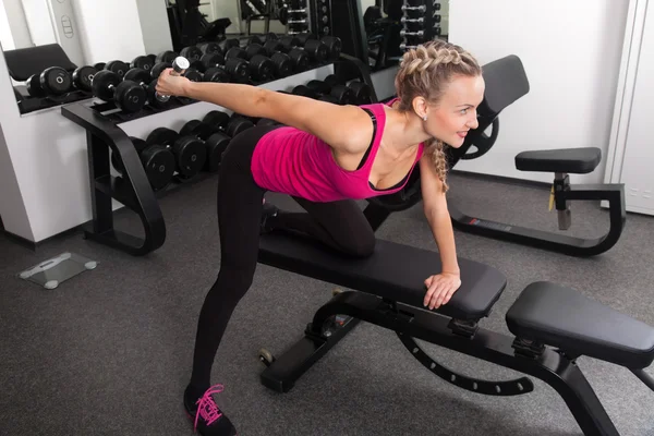 Athletic young woman training with dumbbell — Stock Photo, Image