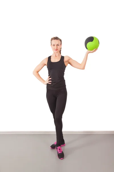 Athletic young woman training with green ball — Stock Photo, Image