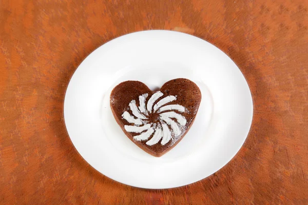 Galleta marrón en forma de corazón con azúcar en polvo —  Fotos de Stock