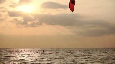 gün batımında denize yelken uçurtma sörfçü