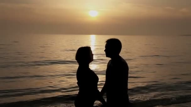 Casal beijando ao pôr do sol na praia — Vídeo de Stock