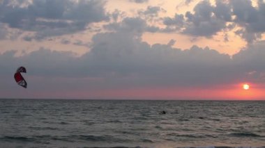 gün batımında denize yelken uçurtma sörfçü